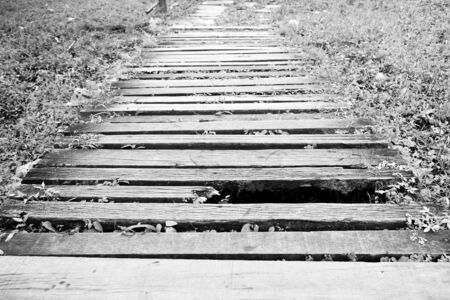 old and dirty broken wood bridge on walk way in black and white photographyの写真素材