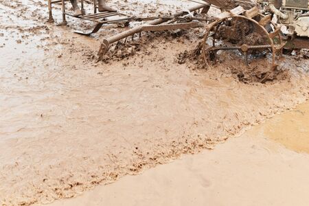 farmer plowing in rice field prepare plant rice under sunlightの写真素材