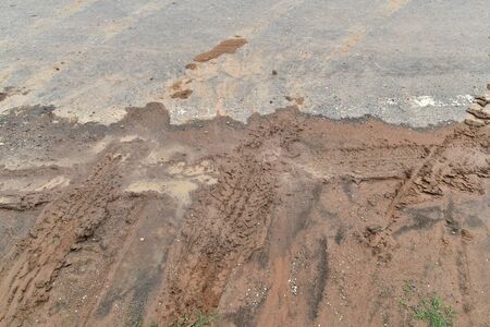 tire track on diry soil and asphalt road for backgroundの写真素材