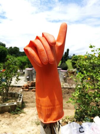 orange rubber gloves show thumb finger upの写真素材