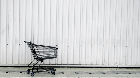 Shopping trolley on a white contrainer. Black cart for background.の写真素材