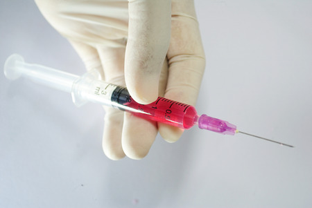 An injection  is an infusion method of putting fluid into the body, usually with a syringe and a hollow needle which is pierced through the skin to a sufficient depth for the material to be administered into the body.の写真素材