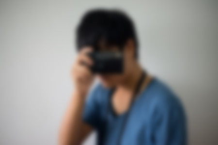 Hipster searching for an interesting subject for his photo shooting and holding a vintage cameraの写真素材