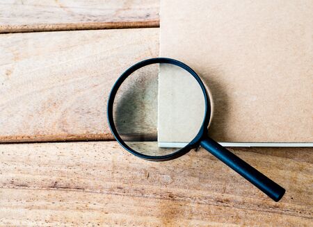 Magnifying Glass and notebook on wood background.の写真素材