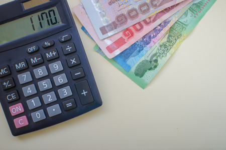 Close up Thai money in one thousand type banknotes with calculator isolated on white background