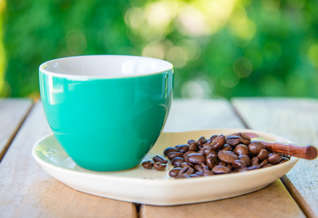 Coffee cup and beans on a green bokeh background.in smooth toneの写真素材