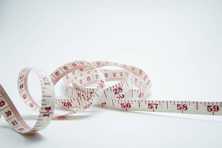 Curved measuring tape. Measuring tape of the tailor. Closeup view of white measuring tape