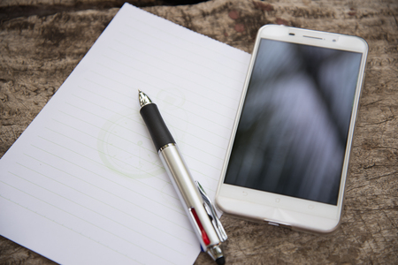 Pen and Notepad on the wooden deskの写真素材