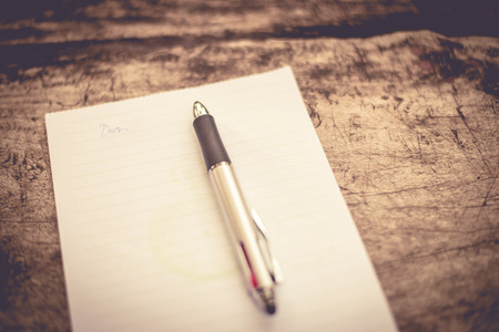 Pen and Notepad on the wooden deskの写真素材