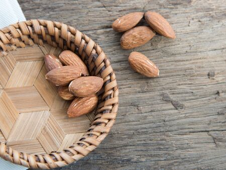 Almonds in brown bowl on wooden backgroundの写真素材