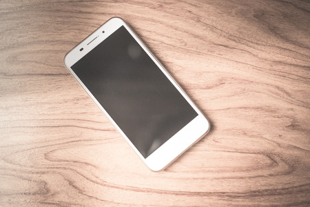 smartphone on wood table in dark tone