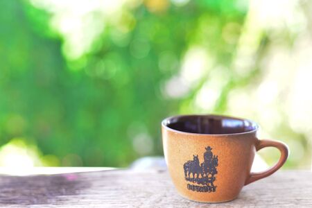 brown cup on green nature background.の写真素材