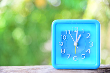 Clock on green nature background.