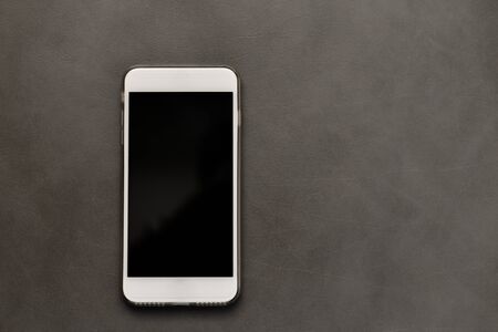 White smart phone on leather texture