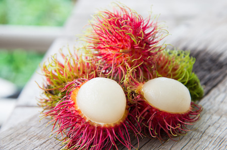 Fresh red rambutan Thai fruit on wood texture.の写真素材