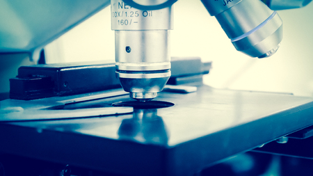 Blurred microscope research concept in blue tone.