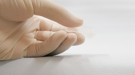 Close up hand scientist with droper on white.の写真素材