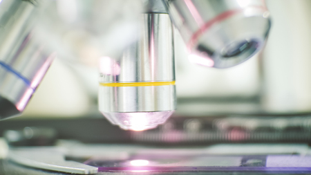 Close up objective lens microscope in laboratory.