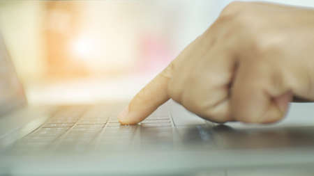 Blurred hand use laptop with sun filter.の写真素材