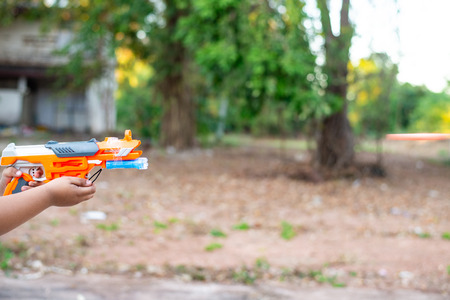 Hand children with toy gun on blur background.の写真素材