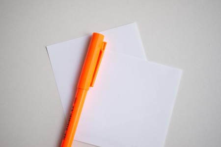 Close up White paper with orange pen.