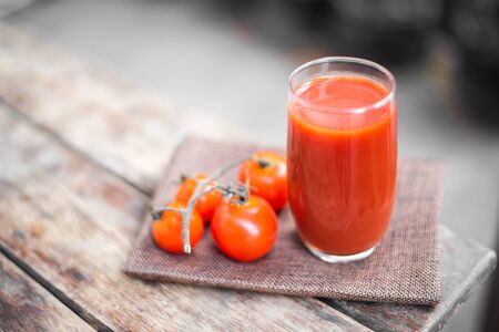 Fresh tomatoes juice in drinking healthy concept on wood table.の写真素材