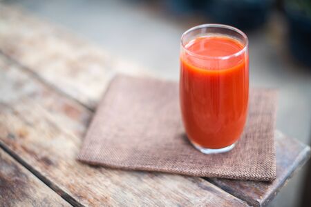 Fresh tomatoes juice in drinking healthy concept on wood table.の写真素材