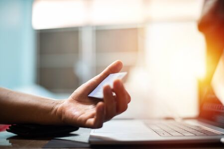 Hand with credit card with laptop in shopping online concept.