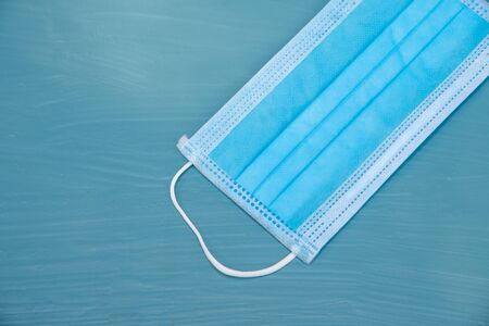 Blue surgical mask  with protected coronavirus on  blue background.