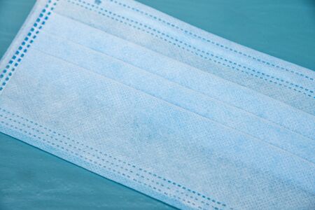 Blue surgical mask  with protected coronavirus on  blue background.