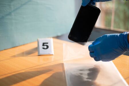 Hand scientist in blue glove with evidence in crime concept.の写真素材