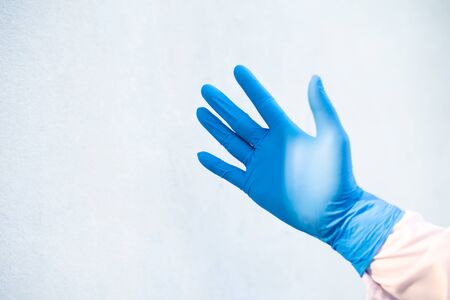 Hand put blue glove on white background medical science concept.