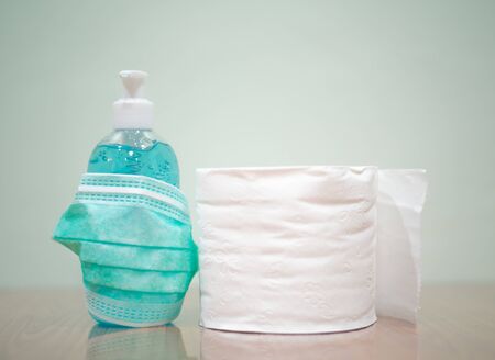 Alcohol gel,surgical mask and toilet paper with protected corona or Covid-19 virus on green tone.の写真素材