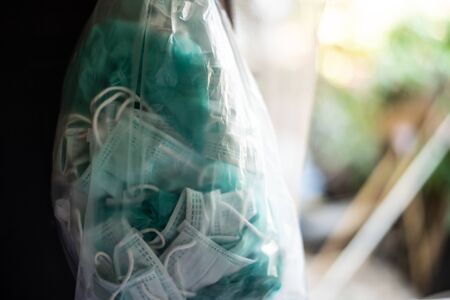 Packing trash surgical mask in plastic bag to prevent corona or Covid-19 virus.の写真素材