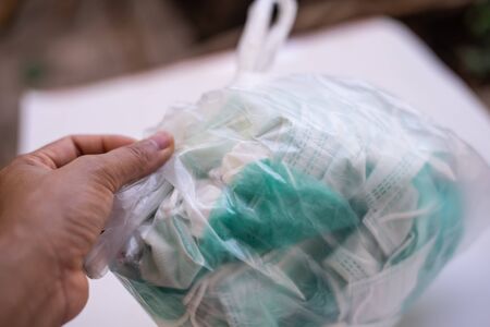 Packing trash surgical mask in plastic bag to prevent corona or Covid-19 virus.