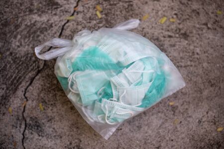 Packing trash surgical mask in plastic bag to prevent corona or Covid-19 virus.の写真素材
