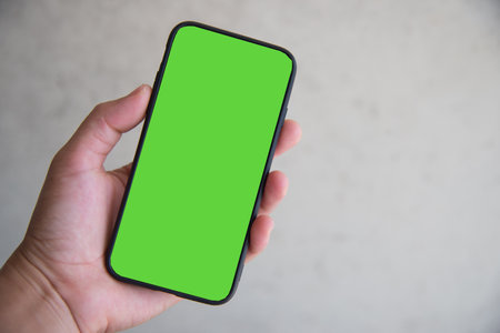 Hand with smartphone green screen background.の写真素材