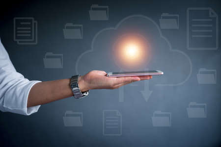 Business man holding smartphone green screen on gray background.の写真素材