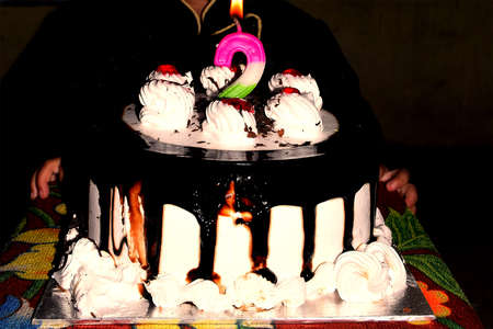 Birthday Drip Cake and burning candle with chocolate and sprinkles isolated black background banner...