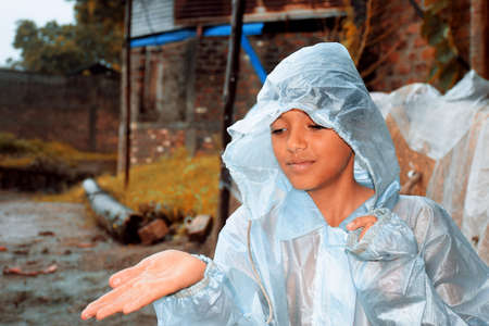 An indian boy wearing rainbows in wet water, village viewの写真素材