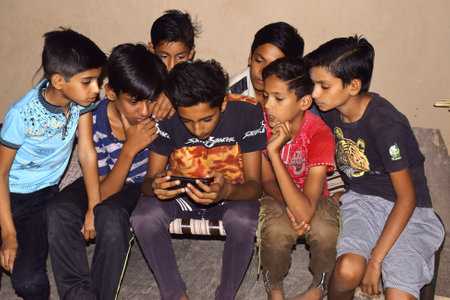 30-05-2020,Dewas. M.P. India. rural children sitting on the bed and playing games on mobile phones
