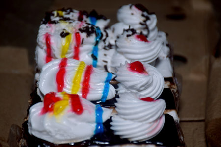 Various slices of cakes, rainbow cake, raspberry cake and almond cake. Sweets decorated with for...
