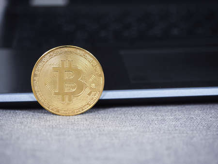 Closeup gold bitcoin with keyboard laptop