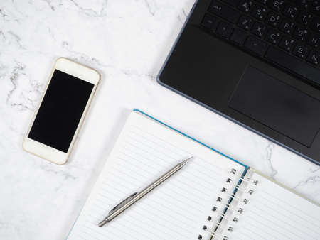 Laptop smartphone and silver pen on the marble table top view copy spaceの写真素材