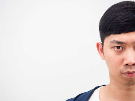 Half face of handsome man serious looking at camera on white isolated copy space side viewの写真素材