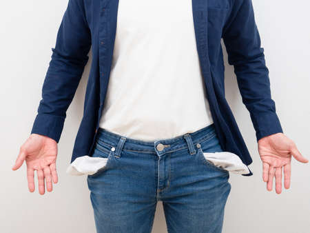 Closeup man body without money in jean pocket and empty hand on white background poor people conceptの写真素材