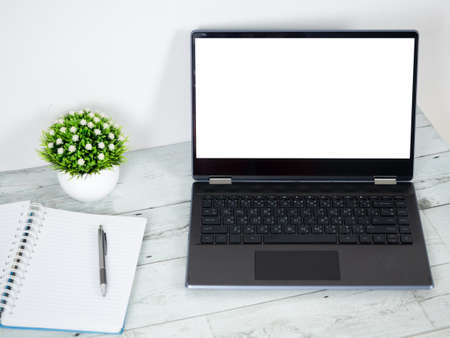 Laptop white screen with notebook blank page and pen on the table work space conceptの写真素材