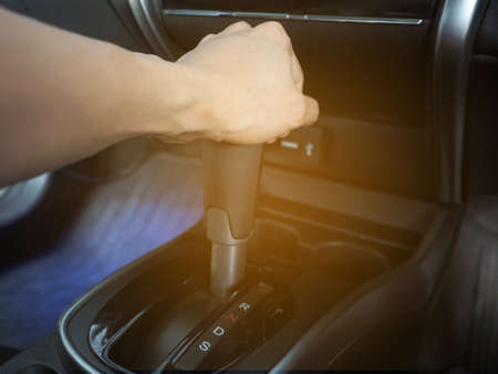 Hand catch at gear auto of car interior the car with light flareの写真素材