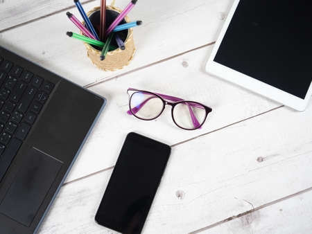 Workspace on table,Laptop pen box glasses and tablet top viewの写真素材