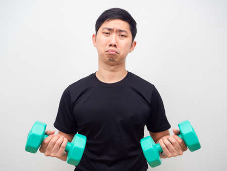 Man holding drumbbell feeling bored to workout sad emotionの写真素材